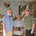 Paul McLean and Peter Bush present a new Ngudradrekai Bible to their overnight host Elder Salabau who wants to read it with his family