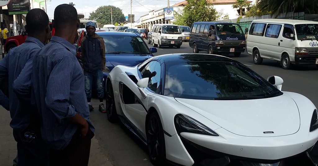Malawians standing by McLaren auto