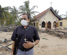 The Rev. Nadarajah Arulnathan, a Methodist pastor in Passikudah, Sri Lanka, stands in front of his church, damaged by the tsunami. Photo - Paul Jeffrey/ACT International