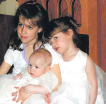Big sisters, Macaela and Madison Ripley enjoy a quiet moment after little sister Katelyn's baptism. Photo - Ina Adamson