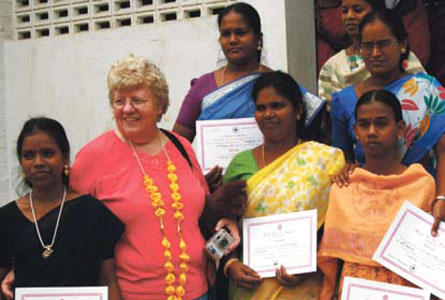 Moderator Wilma Welsh stands with some women who successfully completed typing and computer courses