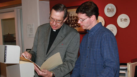 Rev. Dr. Fred Rennie and archivist Bob Anger examine Moments in Time before they are sealed.