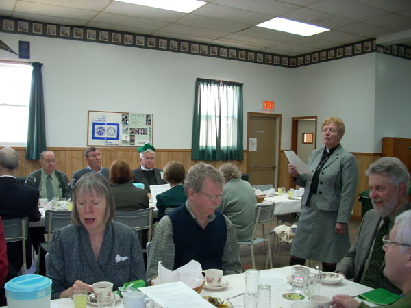 An Irish sing-song on St. Patrick's Day lead by Rev. Jeanette Fleischer at lunch time during the Pictou Presbytery Meeting, Westville, N.S. Revs. Iona Maclean, Glenn Cooper and Richard Sand at front table.