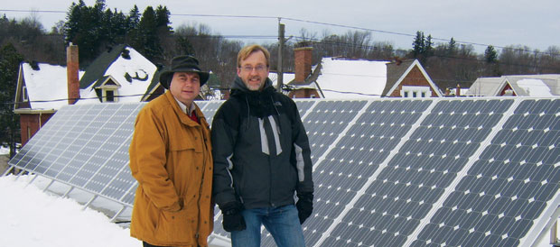 Rev. Scott Sinclair and Dick Hibma show off a set of solar panels on the church roof.