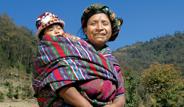 Maria Vasquez, a Mam mother, carries her baby on her back in the traditional Maya fashion. She participates in nutrition classes led by a PCC partner in Guatemala, learning how to provide her family with healthy meals despite budget limitations. Photo by Paul Jeffrey.