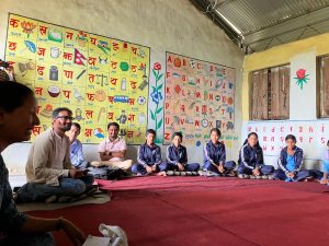 Class seated on red blanket