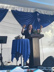 Lora breakig bread at podium